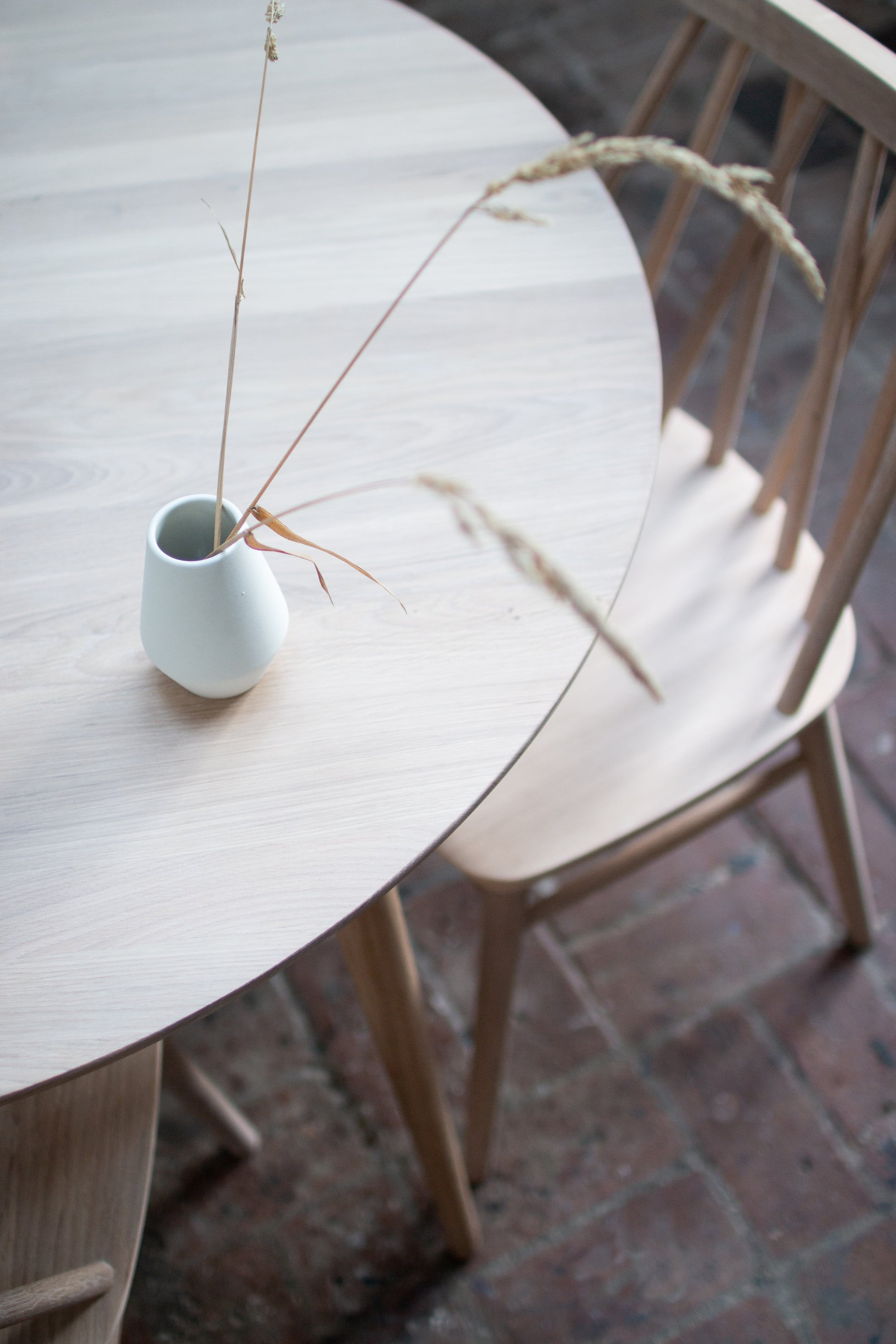 Dia vase 11 centimeter i Milk white farge på et rundt non spisebord